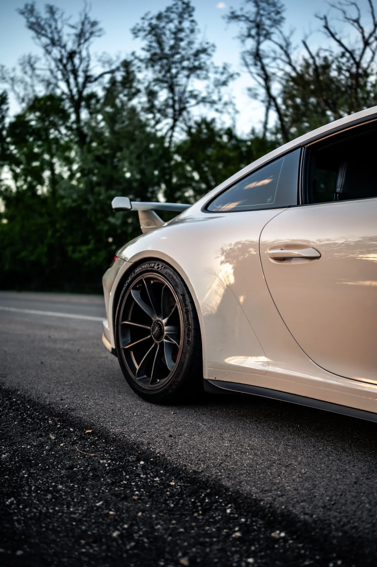 Side and rear wheel detail of a white Porsche 911 GT3 (991.2)
