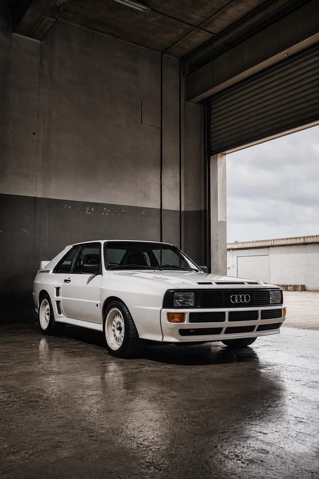 White Audi Sport quattro (B2) in a concrete motorsport workshop