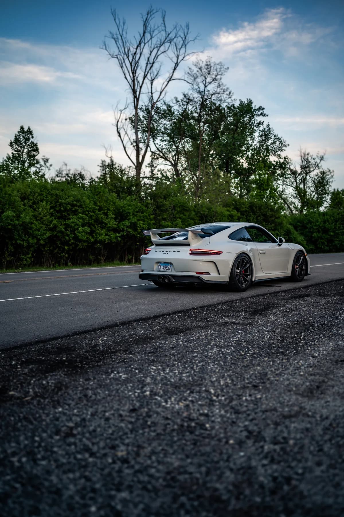 White Porsche 911 GT3 (991.2) photographed from the rear on a quiet road