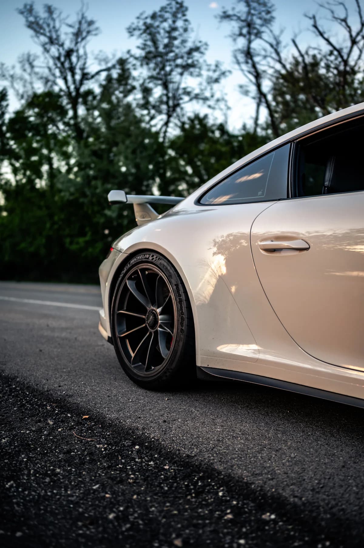 Side and rear wheel detail of a white Porsche 911 GT3 (991.2)