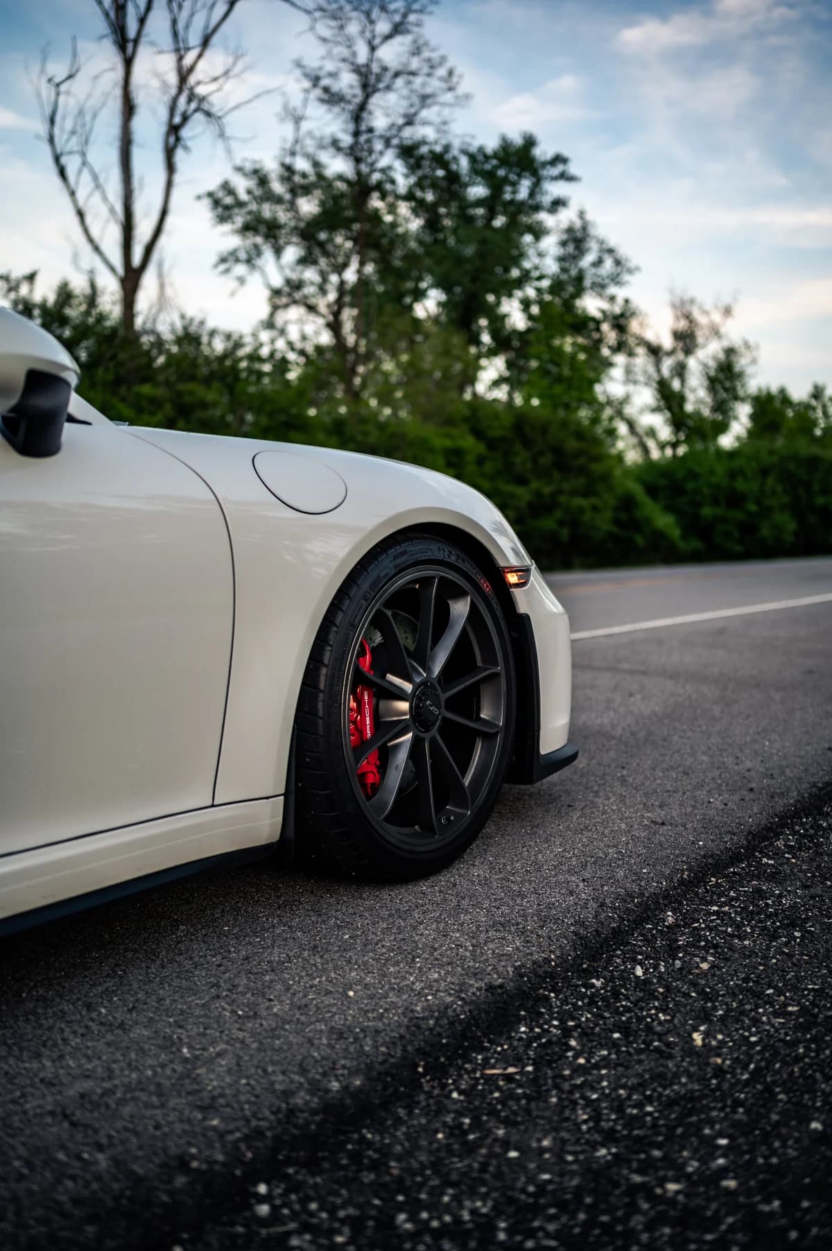 Wheel and brake detail of a white Porsche 911 GT3 (991.2)